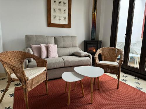 ein Wohnzimmer mit einer Couch und zwei Stühlen und einem Tisch in der Unterkunft Casa Remanso de la Judería in Córdoba