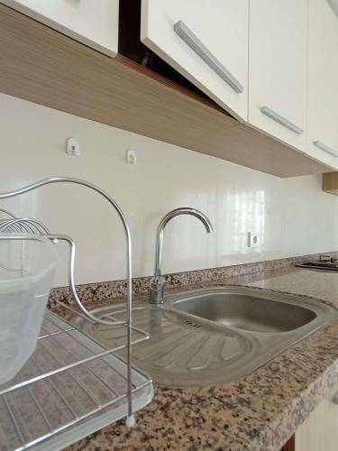 - un évier de cuisine avec un robinet sur un comptoir dans l'établissement begonvil evleri, à Antalya