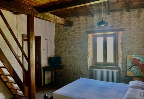 Kama o mga kama sa kuwarto sa ISA-Rooms with private bathroom in a villa with fenced garden surrounded by greenery in the Garfagnana area, shared kitchen, shared hydromassage tub and sauna