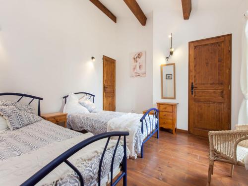 - une chambre avec 3 lits et du parquet dans l'établissement Hirondelle - A beautiful rental home in the heart of The Cathar Country, à Capestang