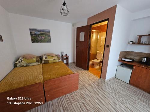 a bedroom with a bed and a bathroom at Pokoje u Joli Polańczyk in Polańczyk
