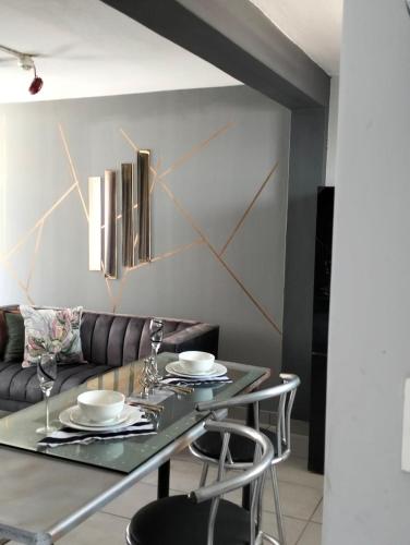 a dining room with a table and a couch at @Derricks Luxury Apartments 2 in Johannesburg