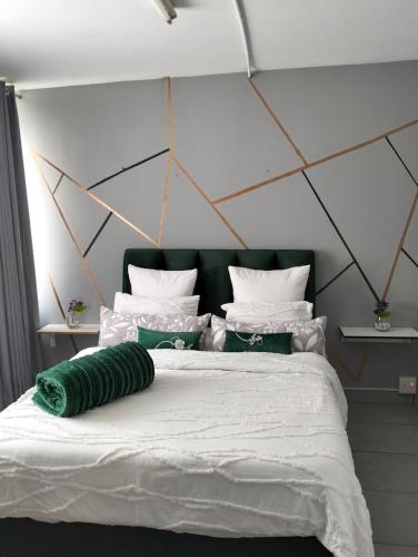 a bed with a green pillow on top of it at @Derricks Luxury Apartments 2 in Johannesburg