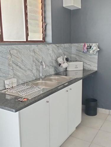 uma cozinha com um lavatório e uma bancada em @Derricks Luxury Apartments 2 em Joanesburgo
