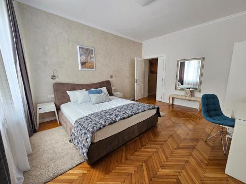 a bedroom with a bed and a blue chair at Urban Downtown Apartment in Belgrade