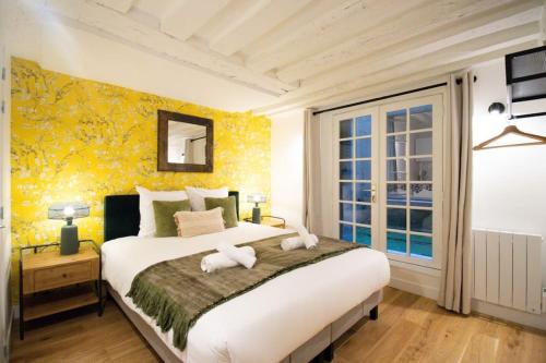 une chambre avec un grand lit avec des serviettes dessus dans l'établissement 3p.cosy flat#6pers#heart of Le Marais, à Paris