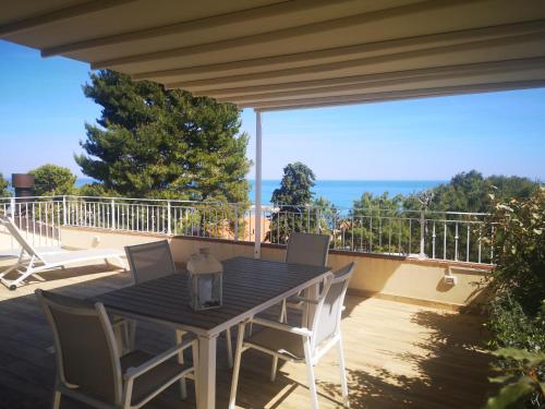 una mesa y sillas en un balcón con vistas al océano en B&B Vivere il Mare, en Numana