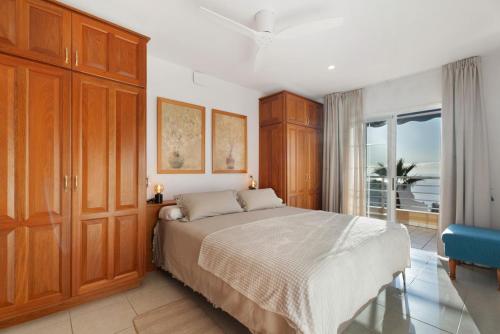 a bedroom with a bed and a large window at Great Sunset Views Los Gigantes in Acantilado de los Gigantes