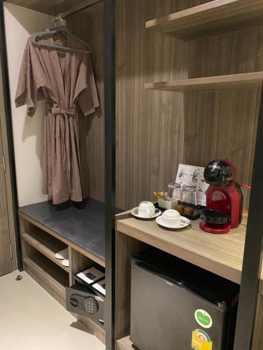 a room with a counter with a microwave and a shirt at The madera lodge pattaya in Jomtien Beach
