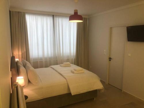 1 dormitorio con 1 cama blanca grande y ventana en Tsakalof 10 Central Apartment by SuperHost Hub en Atenas