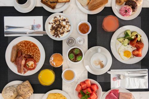 a table topped with plates of breakfast foods at Plaza Regency Hotels in Sliema
