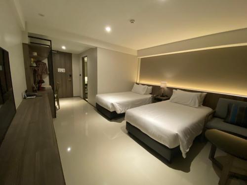 a hotel room with two beds and a couch at The madera lodge pattaya in Jomtien Beach