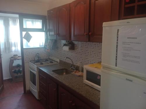 y cocina con fregadero, encimera y heladera. en Bel Solar villa gesell en Villa Gesell