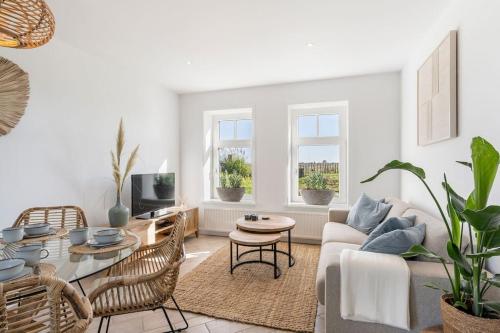 a living room with a couch and a table at Coastal Cottages huisje Bries in Ouddorp