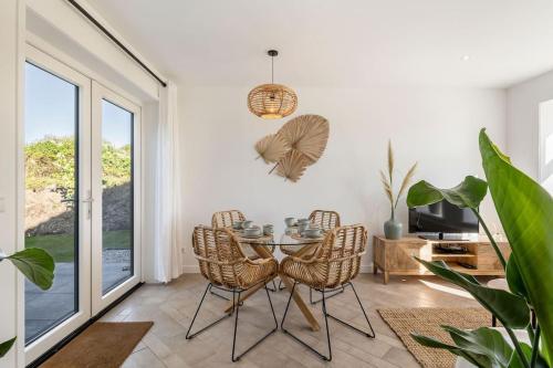 a dining room with a glass table and chairs at Coastal Cottages huisje Bries in Ouddorp