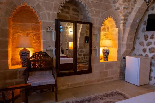 ein Schlafzimmer mit einem Spiegel und einem Stuhl in einem Zimmer in der Unterkunft ELYANS KONAĞI in Mardin