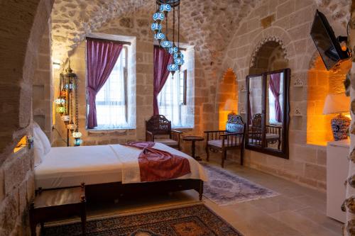 a bedroom with a bed in a room with windows at ELYANS KONAĞI in Mardin