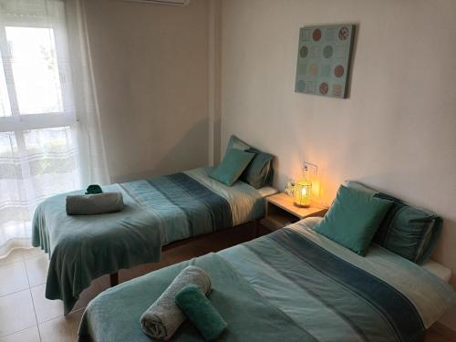 two twin beds in a room with a window at Bella Hermosa in Jávea