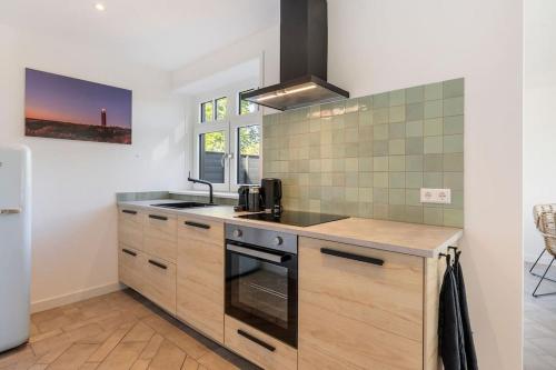 a kitchen with a sink and a stove at Coastal Cottages huisje Bries in Ouddorp