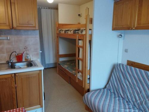 Il comprend une petite cuisine avec un évier et des lits superposés. dans l'établissement La Cascade: Appartement 4 personnes, au Grand-Bornand