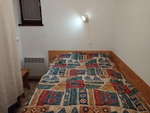Cama en habitación con edredón en La Cascade: Appartement 4 personnes, en Le Grand-Bornand