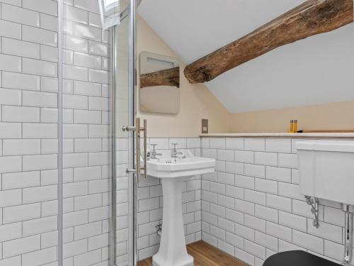ein weißes Bad mit einem Waschbecken und einer Dusche in der Unterkunft Pass the Keys 3 bed Cottage Above Beautiful Country Pub in Baycliff