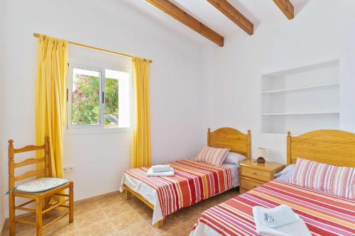 een slaapkamer met 2 bedden en een raam bij Can Juan De S'Hereu in Sant Francesc Xavier