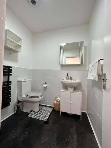 ein weißes Bad mit einem WC und einem Waschbecken in der Unterkunft ASPIRE HOLIDAY HOMES in Bournemouth