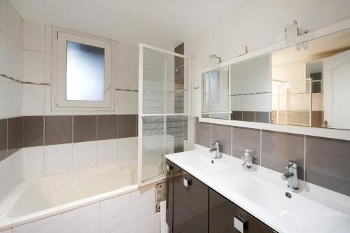 ein Badezimmer mit zwei Waschbecken und einer Badewanne in der Unterkunft Maison 3 chambres jardin 2km plage in Boucau