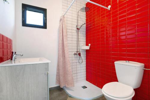 Baño de azulejos rojos con aseo y lavamanos en Un Pedazo de Cielo, en Tuineje