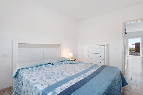 1 dormitorio blanco con 1 cama grande con manta azul en Un Pedazo de Cielo, en Tuineje