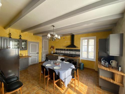 une cuisine avec une table et des chaises dans une pièce dans l'établissement Cancale « la ville es gris », à Cancale