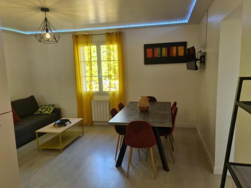 un salon avec une table, des chaises et un canapé dans l'établissement CAP SAINT EMILION-Idéal PROS-horaires adaptables, à Petit-Palais-et-Cornemps