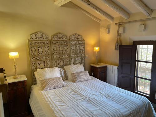 a bedroom with a large bed with two pillows at Exclusiva casa rural con jardín in Madriguera