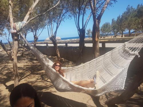 eine Frau, die in einer Hängematte am Strand liegt in der Unterkunft Apartamento El Puerto del Médano in El Médano