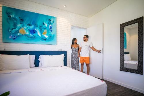 a man and a woman standing in a room with a bed at Grand Oca Maragogi All Inclusive Resort in Maragogi