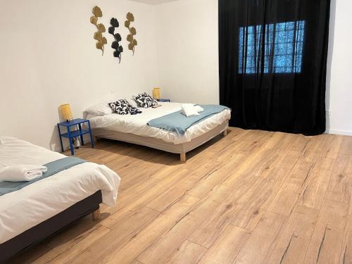 een kamer met 2 bedden en een houten vloer bij Actipole 1 Metz Un Séjour à Part in Metz