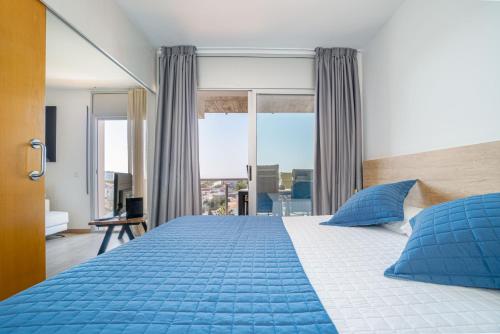 a bedroom with a large blue bed with blue pillows at NIDO 380G in Roses