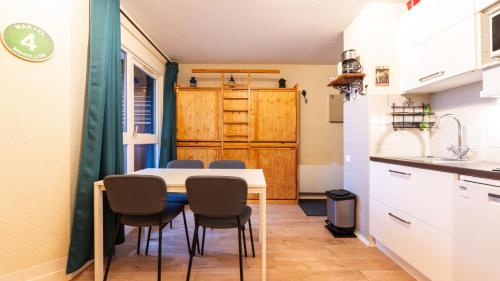 une cuisine et une salle à manger avec une table et des chaises dans l'établissement Grande Neige 44 - Appt renove 4 pers, à Morillon