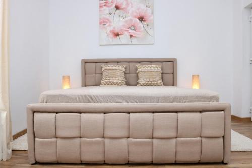 a bed with a tufted bed frame in a bedroom at Herman Apartment Cisnadie in Cisnădie