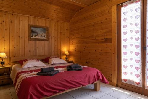 ein Schlafzimmer mit einem Bett in einem Holzzimmer in der Unterkunft Appartement l'éterlou in Sallanches