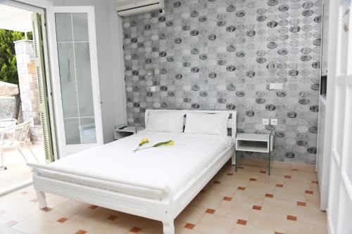 a bedroom with a white bed with two birds on it at Sea Sun in Plomarion