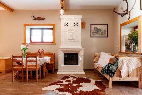 a living room with a table and a fireplace at Chałupa na wsi u Papierzy Sauna, Jacuzzi, SPA in Witów