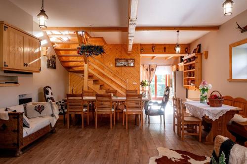 a dining room and living room with a table and chairs at Chałupa na wsi u Papierzy Sauna, Jacuzzi, SPA in Witów