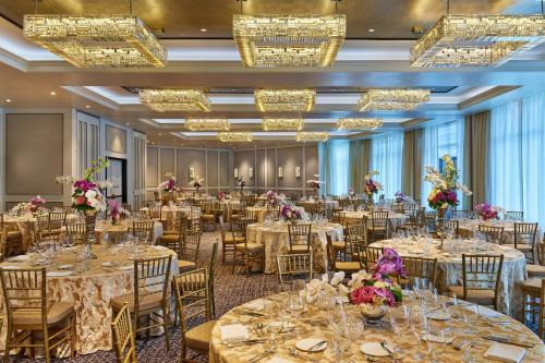 a banquet hall with tables and chairs and chandeliers at The Whitley, a Luxury Collection Hotel, Atlanta Buckhead in Atlanta