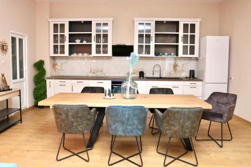 eine Küche mit einem Holztisch und Stühlen in der Unterkunft Herman Apartment Cisnadie in Cisnădie