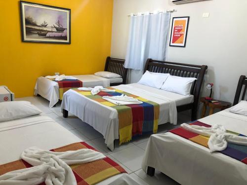 a room with three beds with towels on them at Pousada D Italia in São José da Coroa Grande