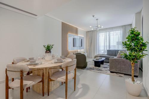 a living room with a table and chairs and a couch at #54 High End 2BR in Mirdif hills in Dubai