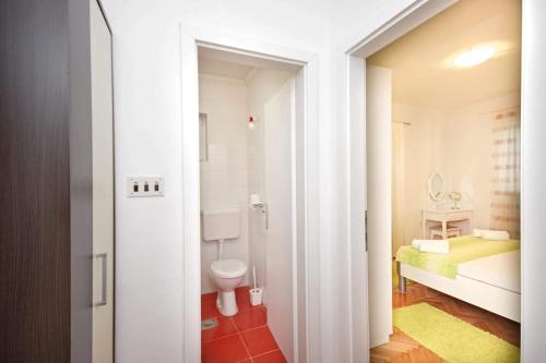 a white bathroom with a toilet and a sink at Apartman Makarska in Makarska