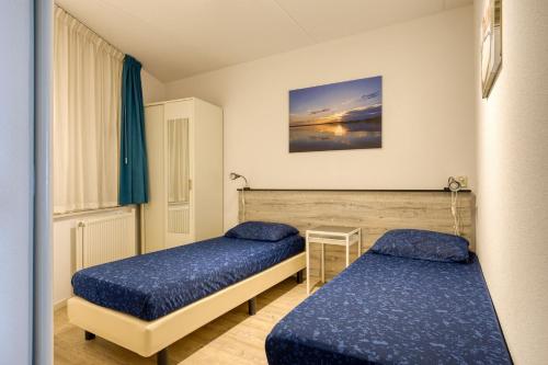 een slaapkamer met 2 bedden in een kamer bij Appartement Strand Makkum in Makkum